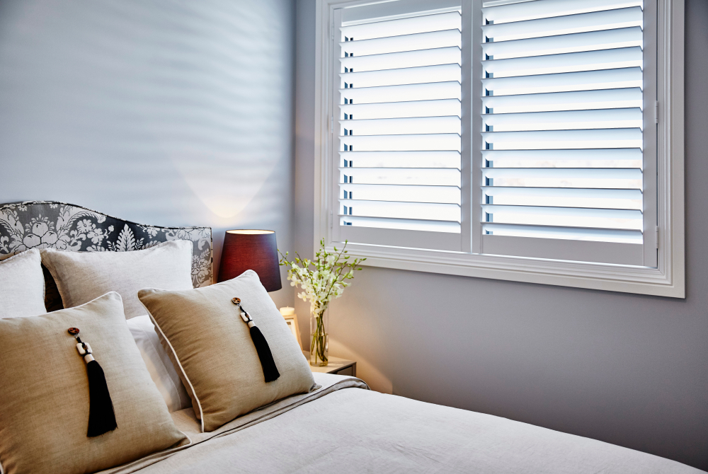 White Plantation Shutters In Bedroom — Blinds, Shutters & Awnings in Wyee, NSW